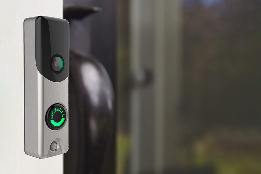 A closeup of a Skybell video doorbell camera installed by a home’s front door.